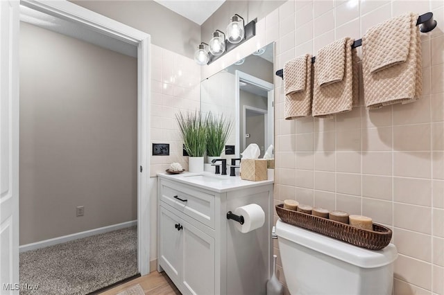 10378 N Pond Ln N Unit 2, Twinsburg, OH 44087 - half bathroom with tile walls, toilet, vanity, and decorative backsplash