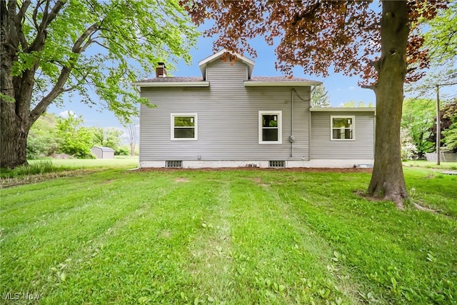 4241 Greenville Rd, Cortland, OH 44410 - rear view of house with a chimney and a lawn