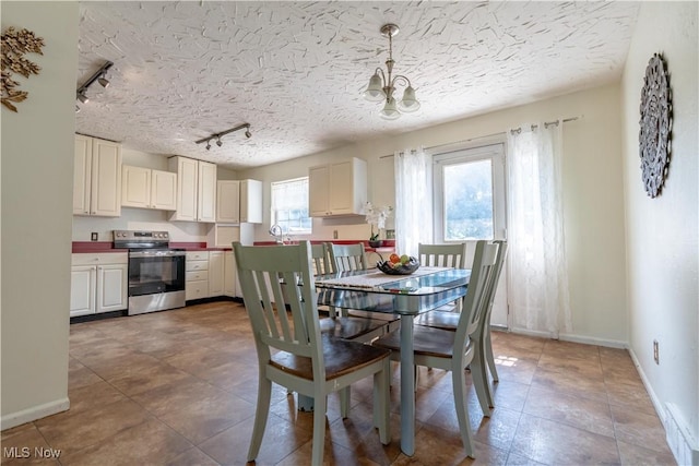14222 Wade Ave NE, Hartville, OH 44632 - tiled dining room with track lighting, a chandelier, baseboards, and a textured ceiling