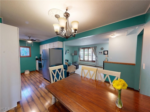 7570 Dahlia Dr, Mentor-On-The-Lake, OH 44060 - dining room featuring a chandelier, a ceiling fan, wood finished floors, baseboards, and a textured ceiling