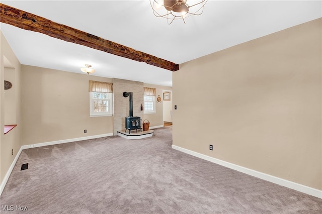 23789 Snell Rd, Columbia Station, OH 44028 - unfurnished living room featuring a wood stove, baseboards, beam ceiling, and carpet