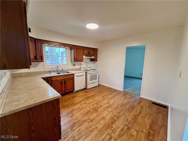 818 2nd St, Brilliant, OH 43913 - kitchen featuring white appliances, a sink, light countertops, light wood-style flooring, and under cabinet range hood