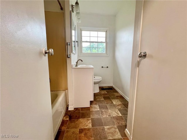 818 2nd St, Brilliant, OH 43913 - full bathroom with stone tile flooring, toilet, vanity, and baseboards