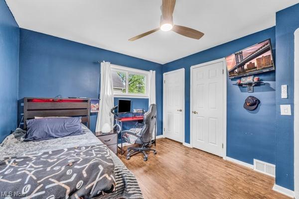 23 Sprague Rd, Berea, OH 44017 - bedroom with wood finished floors, baseboards, a ceiling fan, and multiple closets