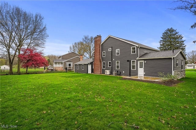 5433 Fleetwood Ave NW, Canton, OH 44718 - back of house featuring a lawn, central AC unit, and a chimney