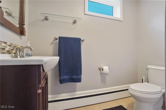 5433 Fleetwood Ave NW, Canton, OH 44718 - half bath featuring toilet, vanity, tile patterned floors, backsplash, and a baseboard heating unit