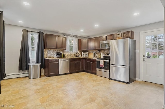 5433 Fleetwood Ave NW, Canton, OH 44718 - kitchen with appliances with stainless steel finishes, a baseboard radiator, backsplash, light countertops, and recessed lighting