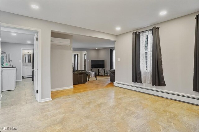 5433 Fleetwood Ave NW, Canton, OH 44718 - unfurnished living room featuring washer / dryer, a baseboard radiator, an AC wall unit, recessed lighting, and baseboards