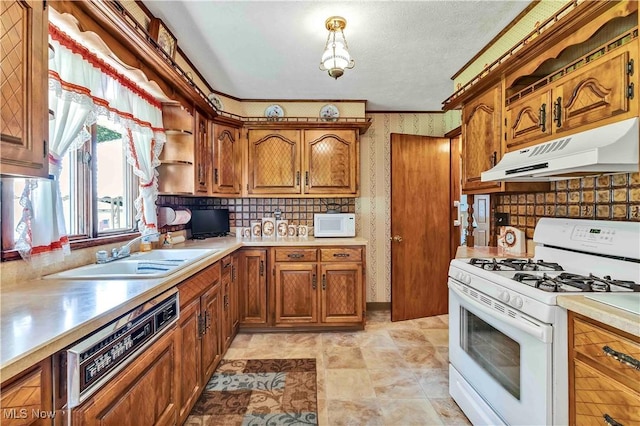 3622 Valacamp Ave SE, Warren, OH 44484 - kitchen featuring white appliances, under cabinet range hood, light countertops, brown cabinetry, and wallpapered walls