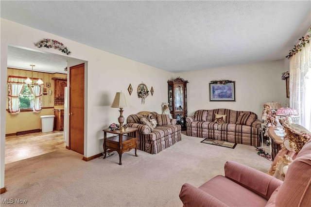 3622 Valacamp Ave SE, Warren, OH 44484 - living room featuring light colored carpet, a chandelier, baseboards, and a textured ceiling