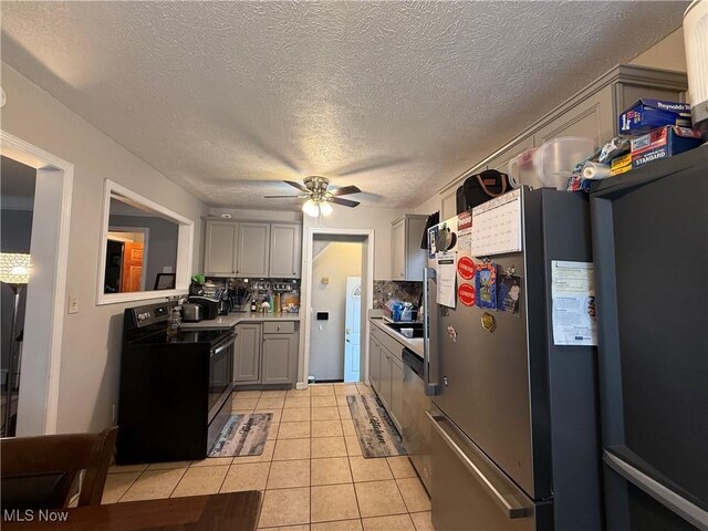 20007 Sunset Dr, Warrensville Heights, OH 44122 - kitchen with stainless steel appliances, light tile patterned floors, ceiling fan, light countertops, and decorative backsplash