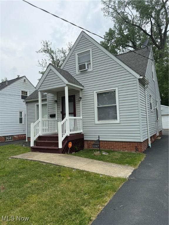 20007 Sunset Dr, Warrensville Heights, OH 44122 - bungalow featuring a front yard, roof with shingles, a porch, crawl space, and a garage