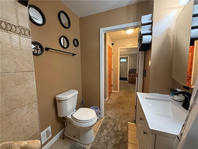 20007 Sunset Dr, Warrensville Heights, OH 44122 - bathroom featuring toilet, vanity, tile patterned flooring, and baseboards