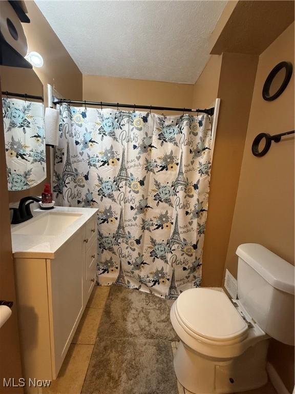 20007 Sunset Dr, Warrensville Heights, OH 44122 - full bathroom with toilet, vanity, tile patterned floors, curtained shower, and a textured ceiling