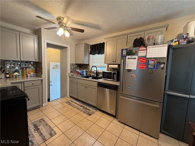 20007 Sunset Dr, Warrensville Heights, OH 44122 - kitchen featuring appliances with stainless steel finishes, a sink, gray cabinets, a ceiling fan, and light countertops