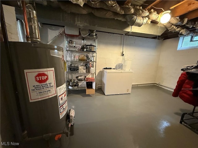 20007 Sunset Dr, Warrensville Heights, OH 44122 - basement featuring water heater, concrete block wall, and fridge