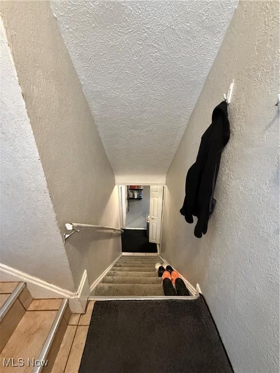 20007 Sunset Dr, Warrensville Heights, OH 44122 - stairs with a textured ceiling and a textured wall