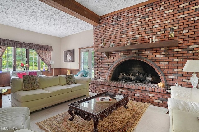8650 Hidden Hills Dr SE, Howland, OH 44484 - living area featuring a textured ceiling, carpet, wainscoting, a brick fireplace, and beam ceiling