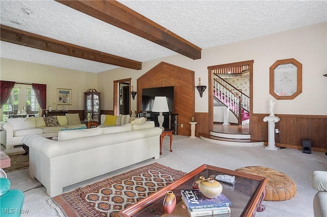 8650 Hidden Hills Dr SE, Howland, OH 44484 - living room featuring a textured ceiling, beamed ceiling, wooden walls, a wainscoted wall, and light carpet