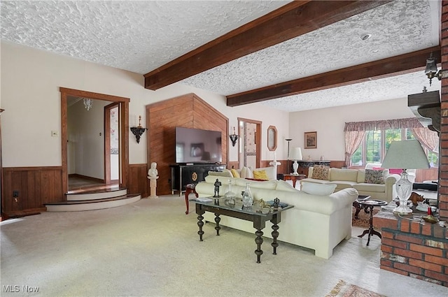 8650 Hidden Hills Dr SE, Howland, OH 44484 - living room featuring a textured ceiling, wainscoting, beamed ceiling, carpet flooring, and wooden walls