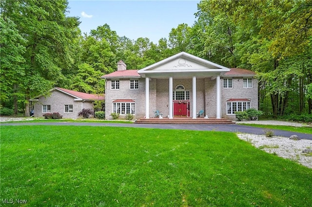 8650 Hidden Hills Dr SE, Howland, OH 44484 - greek revival inspired property with a front lawn, a chimney, and a porch