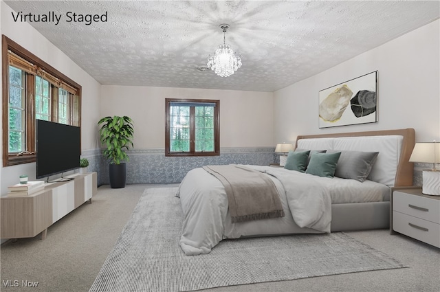8650 Hidden Hills Dr SE, Howland, OH 44484 - bedroom with a textured ceiling, light colored carpet, a chandelier, and a wainscoted wall
