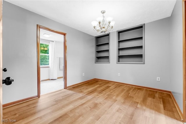 10790 Good Hope Pike, Jane Lew, WV 26378 - empty room featuring a chandelier, light wood finished floors, built in shelves, and baseboards