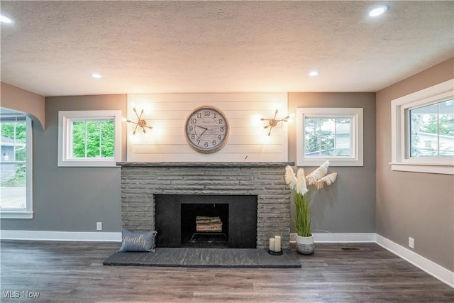 680 Isle View Dr, Akron, OH 44319 - detailed view of a textured ceiling, a fireplace with raised hearth, wood finished floors, baseboards, and recessed lighting