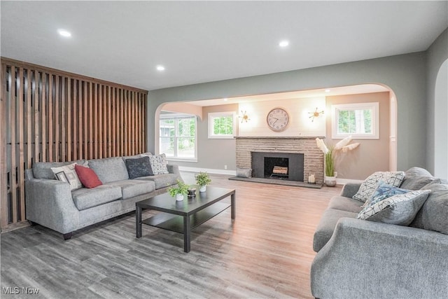 680 Isle View Dr, Akron, OH 44319 - living area with arched walkways, baseboards, wood finished floors, recessed lighting, and a brick fireplace