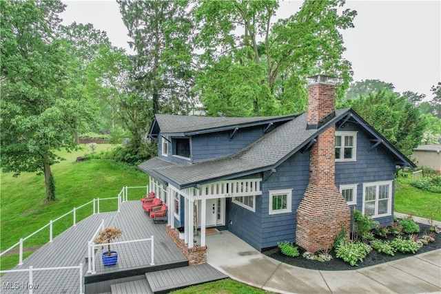 680 Isle View Dr, Akron, OH 44319 - rear view of property with a wooden deck, a chimney, a shingled roof, and a yard