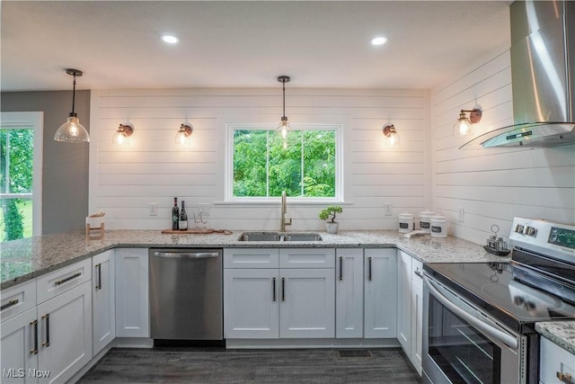 680 Isle View Dr, Akron, OH 44319 - kitchen with appliances with stainless steel finishes, a sink, wall chimney exhaust hood, healthy amount of natural light, and wood walls