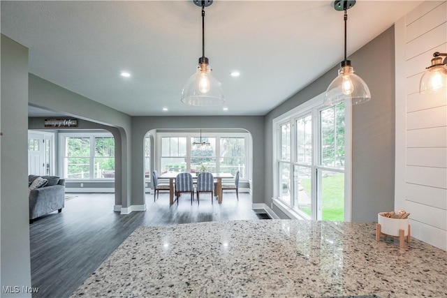 680 Isle View Dr, Akron, OH 44319 - kitchen with dark wood-style flooring, recessed lighting, light stone countertops, arched walkways, and hanging light fixtures