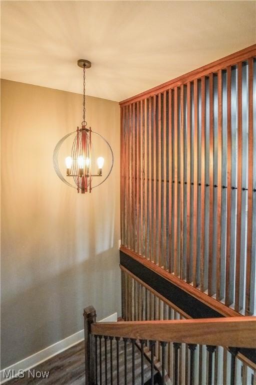 680 Isle View Dr, Akron, OH 44319 - staircase featuring a chandelier, baseboards, and wood finished floors