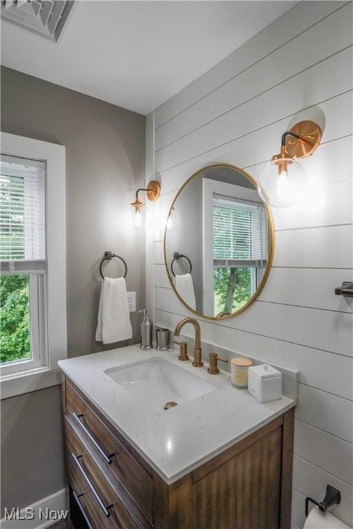 680 Isle View Dr, Akron, OH 44319 - bathroom with healthy amount of natural light, vanity, and wooden walls