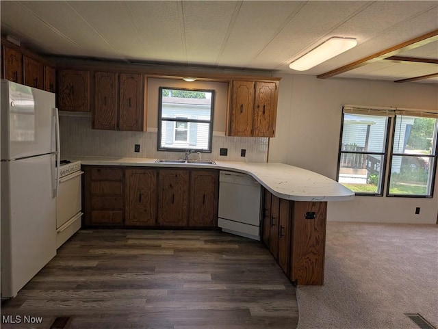 200 E St SW, Navarre, OH 44662 - kitchen featuring white appliances, a peninsula, light countertops, a sink, and dark wood-style floors