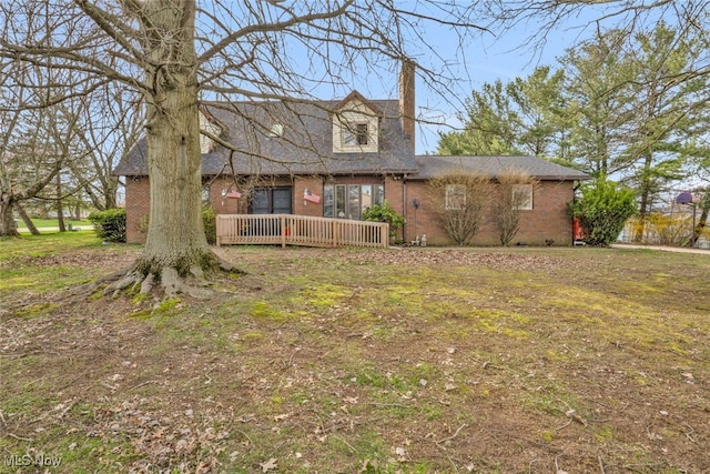 7687 Galena St NW, Massillon, OH 44646 - view of front facade featuring a chimney, brick siding, a wooden deck, and a front yard
