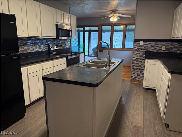 7687 Galena St NW, Massillon, OH 44646 - kitchen featuring stainless steel appliances, a sink, dark wood-style floors, ceiling fan, and dark countertops
