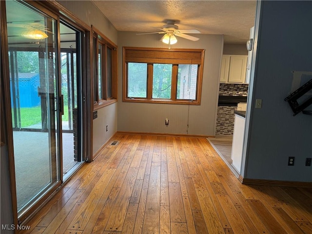7687 Galena St NW, Massillon, OH 44646 - unfurnished dining area featuring light wood-style flooring, ceiling fan, and baseboards