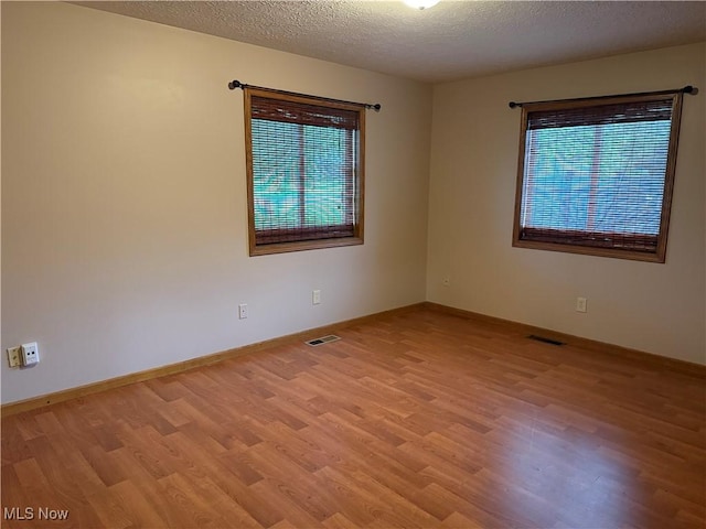 7687 Galena St NW, Massillon, OH 44646 - spare room with wood finished floors, a textured ceiling, and baseboards