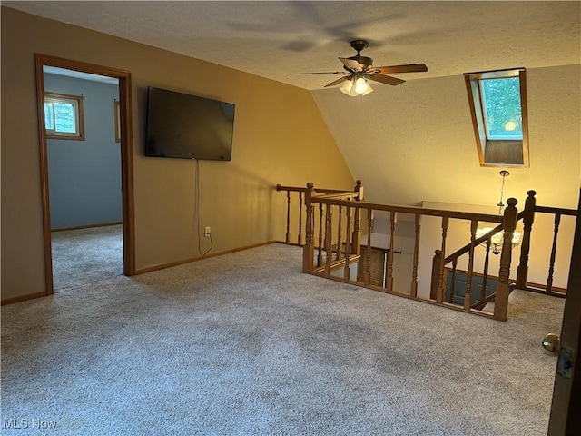 7687 Galena St NW, Massillon, OH 44646 - carpeted empty room with a ceiling fan, a textured ceiling, lofted ceiling, and baseboards