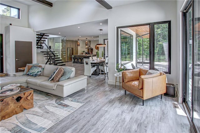 4385 Good Rd, Seville, OH 44273 - living room with stairway, wood finished floors, a high ceiling, and beamed ceiling