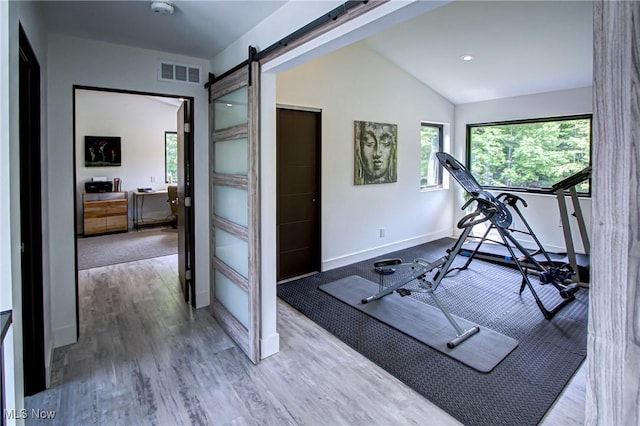 4385 Good Rd, Seville, OH 44273 - exercise room featuring plenty of natural light, a barn door, baseboards, lofted ceiling, and wood finished floors