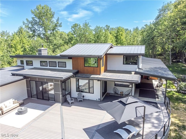4385 Good Rd, Seville, OH 44273 - back of house featuring a sunroom, a chimney, view of wooded area, and a patio area