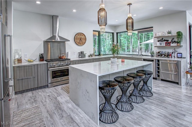 4385 Good Rd, Seville, OH 44273 - kitchen with wall chimney range hood, stainless steel appliances, modern cabinets, gray cabinetry, and a kitchen breakfast bar