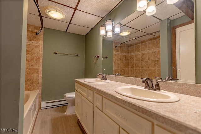 6226 Mayburn Barclay Rd, Kinsman, OH 44428 - full bath featuring a baseboard heating unit, a drop ceiling, toilet, double vanity, and wood finished floors
