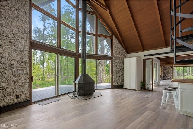 6226 Mayburn Barclay Rd, Kinsman, OH 44428 - unfurnished living room featuring high vaulted ceiling, a wood stove, wood ceiling with exposed beams, plenty of natural light, and wood finished floors