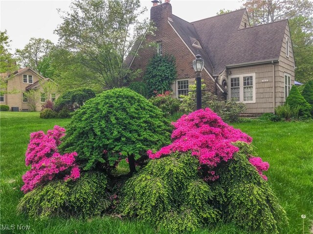 1415 Inwood Rd, Alliance, OH 44601 - view of side of home with roof with shingles, a chimney, and a lawn