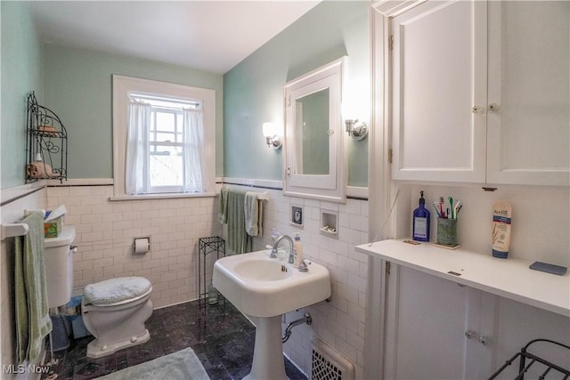 1415 Inwood Rd, Alliance, OH 44601 - bathroom featuring toilet, tile walls, and a wainscoted wall