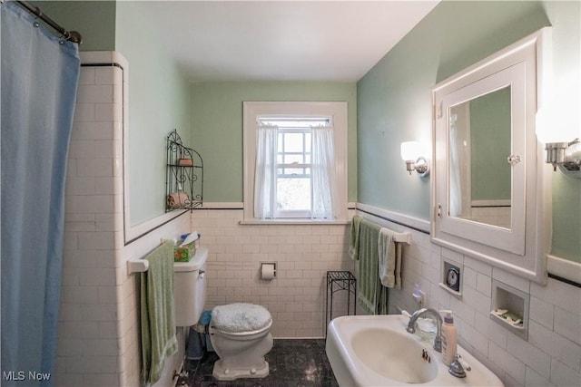 1415 Inwood Rd, Alliance, OH 44601 - bathroom with a sink, tile walls, toilet, a wainscoted wall, and a shower with shower curtain