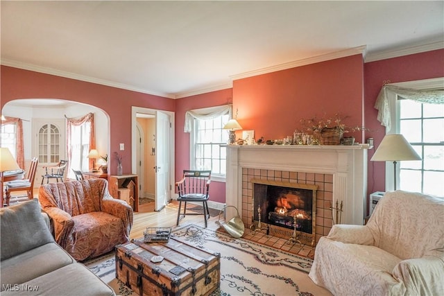 1415 Inwood Rd, Alliance, OH 44601 - living area with ornamental molding, arched walkways, a tiled fireplace, and wood finished floors